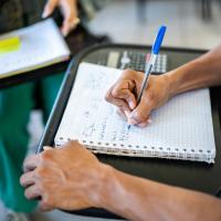 close up of college student doing math work in a spiral notebook