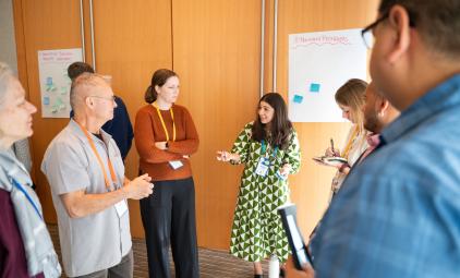 Group of educators standing in a circle discussing together