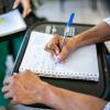 close up of college student doing math work in a spiral notebook